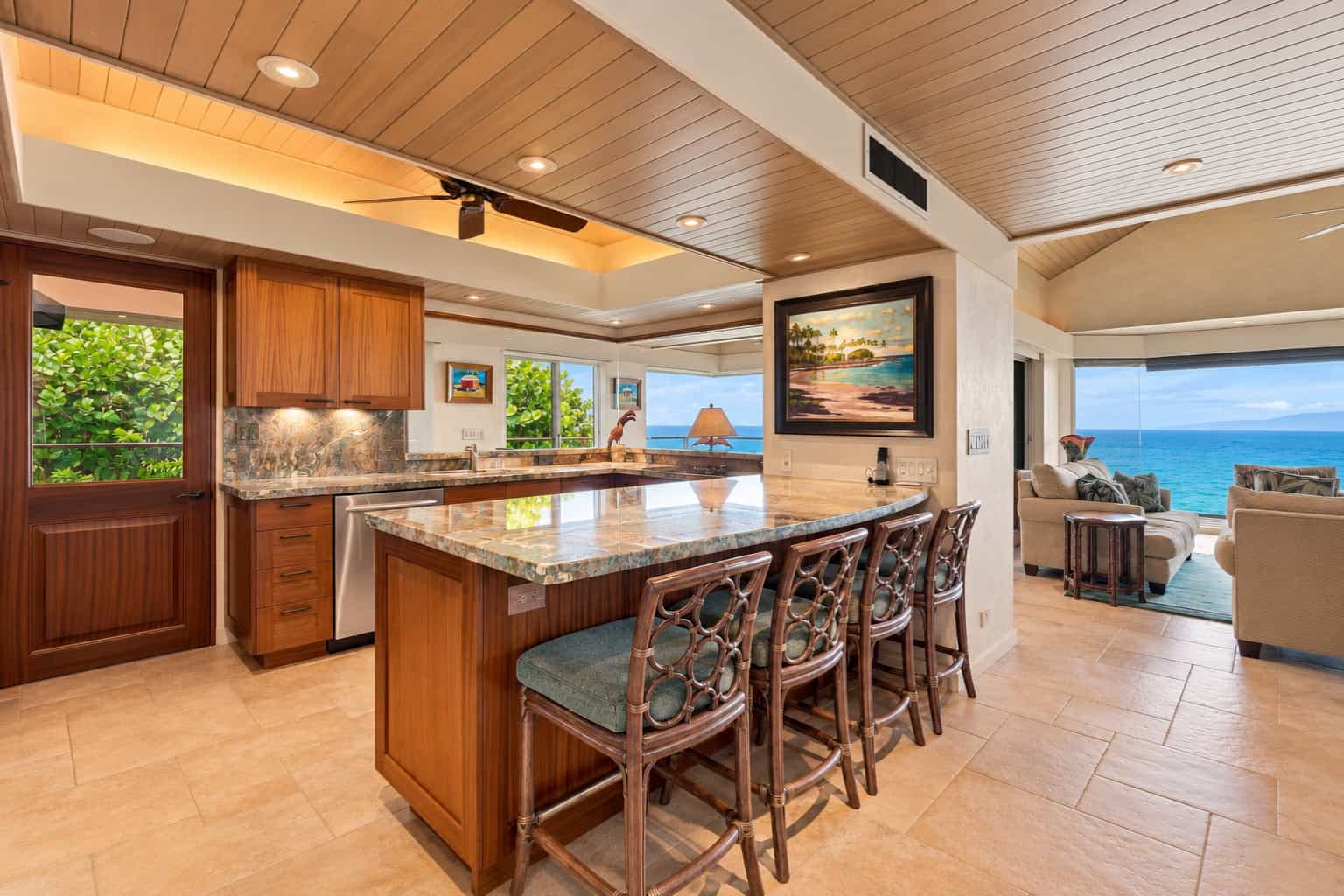 Upgraded kitchen of Residence 1104 with natural stone countertops and ocean view